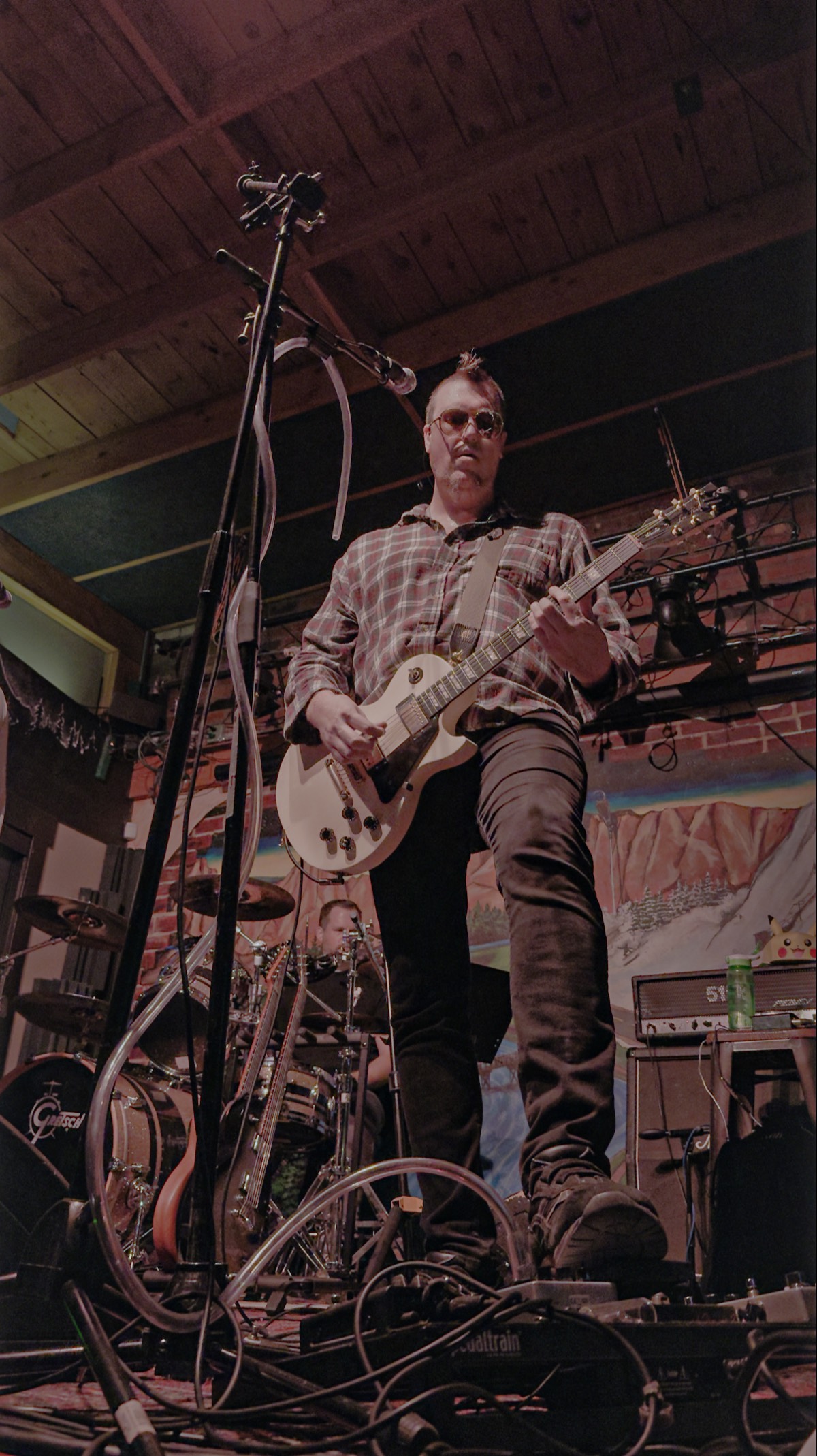 Andy from That 90s Band playing guitar under stage lights